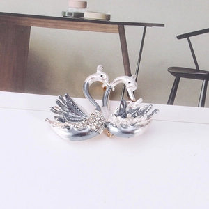 Vue macro de broche cygne double avec émail blanc et détails en cristaux étincelants