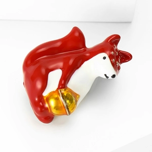 Détail de la broche renard en émail rouge avec clochette dorée et fini brillant
