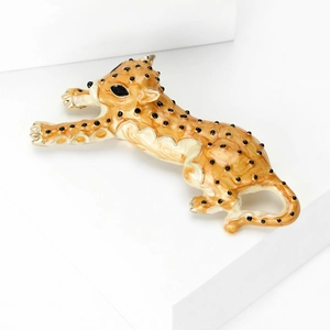 Close-up of leopard brooch with yellow enamel, black spots and golden metal edges