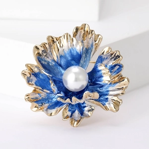 Close-up of blue enamel peony flower brooch with white pearl and gold metal finish