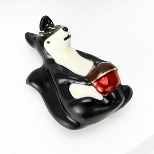 Gros plan d'une broche en émail husky avec des bords dorés et un détail de bol rouge