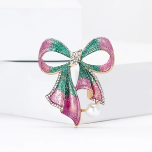 Broche nœud en émail rose et vert avec strass et perle sur supports géométriques blancs