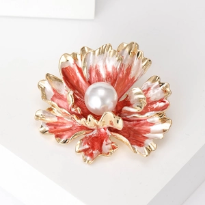 Macro shot of an elegant red and white enamel peony flower brooch with a large central pearl