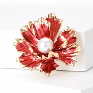 Detail of red peony brooch with gold plating and a large white pearl center on white block