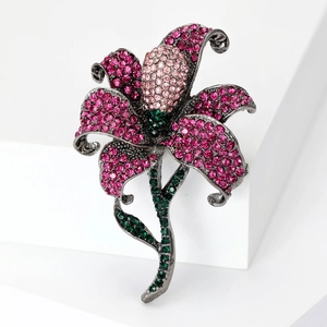 Macro shot of lily brooch with pink gradient rhinestones and green crystal accents