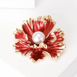 Detailed macro view of a red peony flower brooch with gold edges and a center pearl