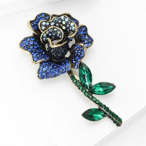 Detailed view of luxury rose brooch with royal blue rhinestones and gold alloy stems