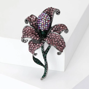 Exquisite rose brooch with pink rhinestones and green gems on a dark metal base