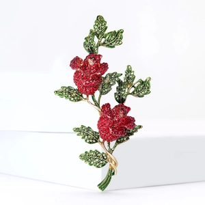 Broche fleur de rose élégante avec strass rouges et verts sur base plaquée or