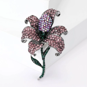 Detailed close-up of a lily brooch with pink and green rhinestones on black metal base