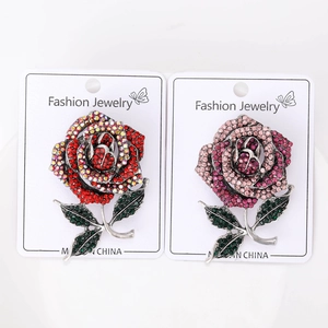 Detail of rose brooches set featuring red and pink rhinestones on silver alloy bases