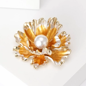 Detailed close-up of a peony flower brooch with a large white pearl and textured gold petals