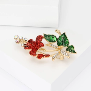 Elegant gold plated flower brooch with red rhinestones and green enamel leaves