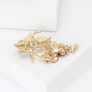 Detail view of the gold-plated flower brooch back showing the metal pin and safety clasp