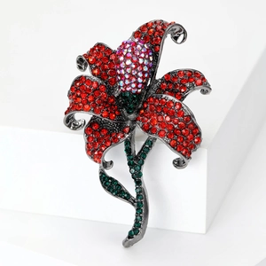 Macro detail of gunmetal rose brooch featuring pavé red crystals and aurora accents