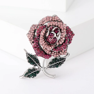 Sparkling rose flower brooch with pink rhinestones and silver stem on white block