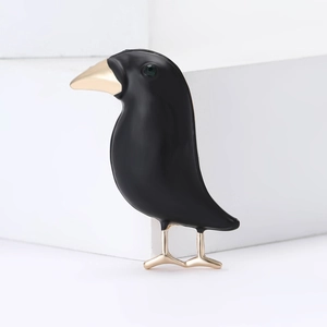 Creative black enamel raven bird brooch with golden beak and green gem on minimalist steps