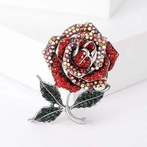 Macro view of crystal rose brooch with sparkling red and green rhinestones on silver base