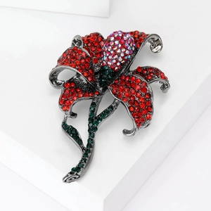 Detail of floral rose brooch with vibrant red rhinestones and a large central crystal