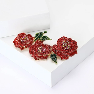Broche élégante roses rouges en cristal avec feuilles vertes sur socle blanc
