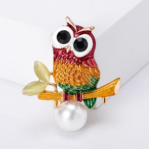 Colorful enamel owl brooch with white pearl and gold metal finish on white stand