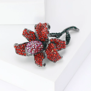 Detail of rose brooch with red and green rhinestones on minimalist white block
