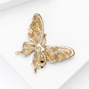 Back view of a gold-plated butterfly brooch with hollow metalwork and safety pin