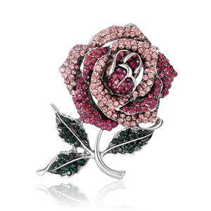 Elegant rose brooch with pink and red crystals in silver alloy on a white background