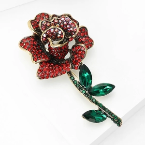 Macro detail of luxury rose brooch with red rhinestones and vintage gold finish