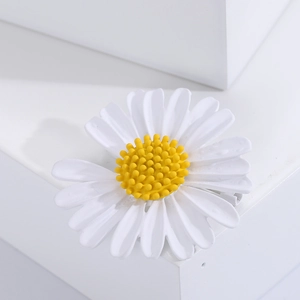 Dettaglio macro di spilla a margherita con petali bianchi su base in pietra bianca