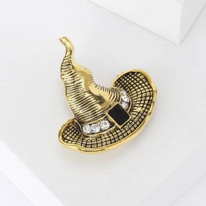 Makro-Detail der goldenen Hexenhut-Brosche mit Strasssteinen und Vintage-Textur