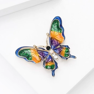 Detailed macro view of colorful enamel butterfly brooch with inlaid rhinestones and gold plating