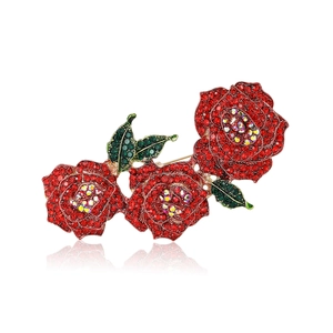 Élégante broche florale avec trois roses en strass rouges et feuilles vertes sur base d'or