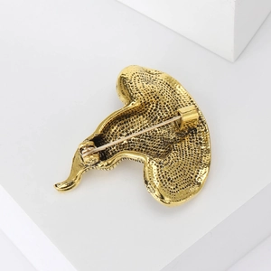 Detailansicht der Rückseite der goldenen Hexenhut-Brosche mit Sicherheitsnadel und Textur