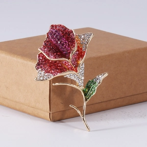 Detailed macro view of gold rose brooch featuring colorful rhinestones on petal details