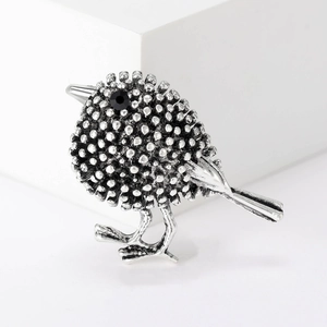 Détail macro de la broche oiseau en argent rétro avec perles et œil en pierre noire