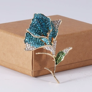 Detailed macro view of the rose brooch with blue and green rhinestones on gold base