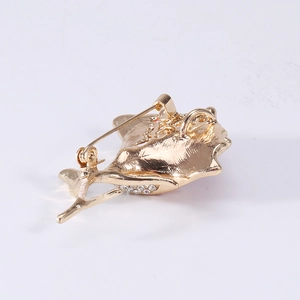 Elegant gold flower brooch with sparkling crystals showing back pin and pendant loop