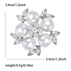 Detailed view of silver flower brooch with five white pearls and sparkling rhinestones