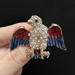Detailed close-up of eagle brooch with red and blue enamel and sparkling rhinestones