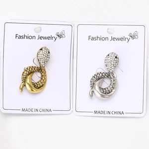 Detailed close-up of snake brooches in gold and silver finish with crystal rhinestones