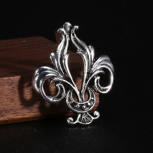 Macro shot of vintage fleur-de-lis brooch with detailed black oxidation on aged silver metal