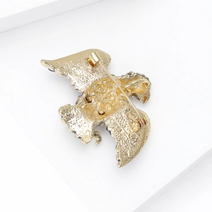 Back view of gold eagle brooch showing alloy texture and horizontal safety pin closure