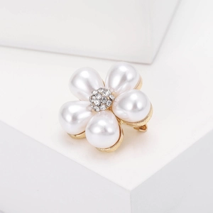 Détail de la broche fleur avec perles blanches en forme de goutte et cristaux centraux