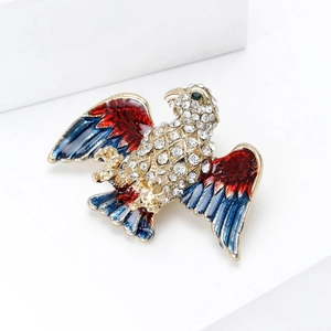 Macro shot of eagle brooch with blue and red enamel wings and sparkling rhinestones