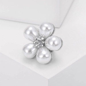 Vue macro d'une broche fleur en perles avec pétales en goutte d'eau et diamants brillants