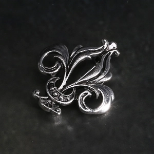 Detailed macro shot of vintage silver iris brooch with gothic oxidized metal texture