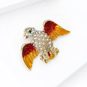 Detail of an eagle brooch with red-yellow enamel wings and sparkling rhinestones