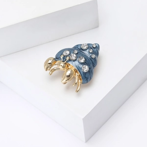 Detailed macro view of the hermit crab brooch featuring blue enamel and sparkling rhinestones