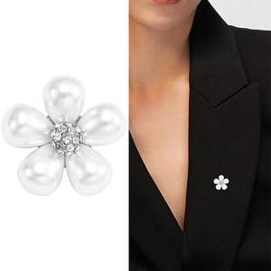 Élégante broche fleur à pétales de perles blanches et centre scintillant sur un blazer